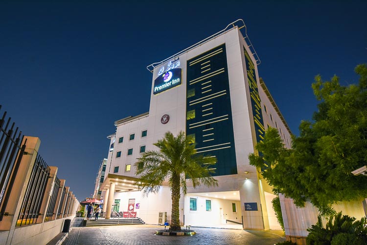 Entrance to Premier Inn Dubai International Airport hotel at night 