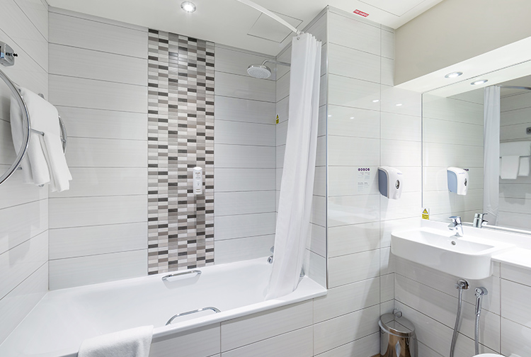 Private en-suite bathroom with bath and shower in hotel near Doha Airport