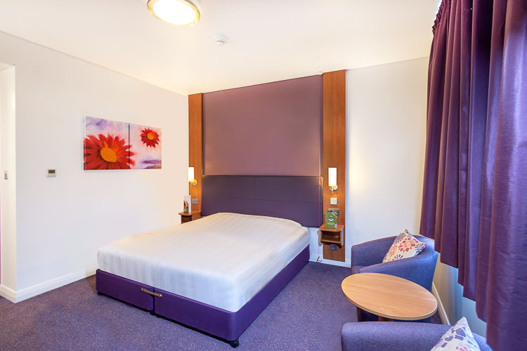 Double room with large bed and seating area at Premier Inn Abu Dhabi International Airport hotel