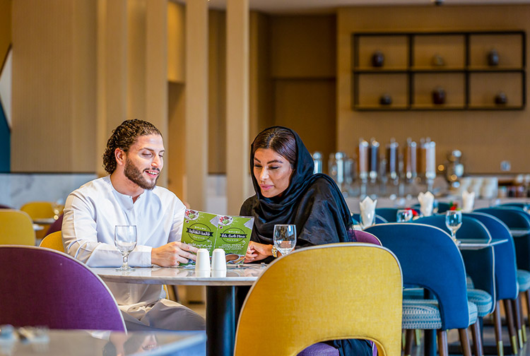 Arab guests enjoying dining at restaurant in Dragon Mart hotel in Dubai