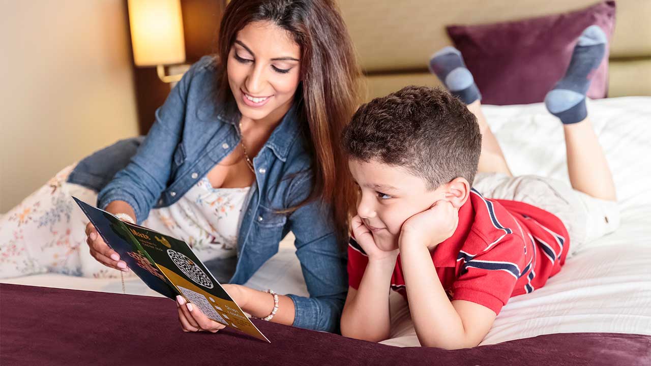 image of mother reading bed time stories for her kid at premier inn hotel