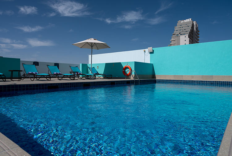 Rooftop swimming pool with towels and sun loungers in Silicon Oasis hotel in Dubai